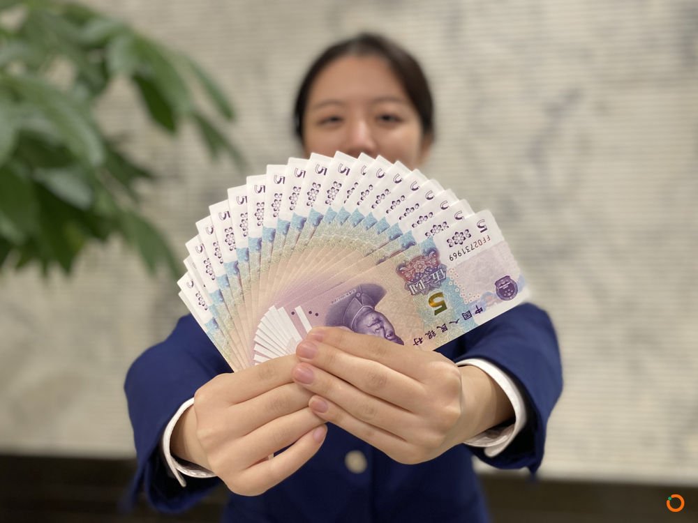 图为交通银行北京市分行营业部一名工作人员展示新版5元纸币